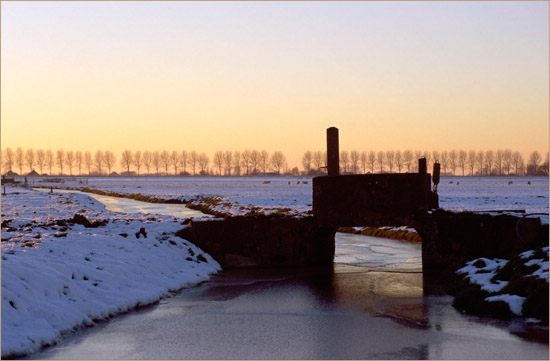 De Kleine Waterling van de Beetskoog bij een winterse zonsondergang, met een van de bruggetjes