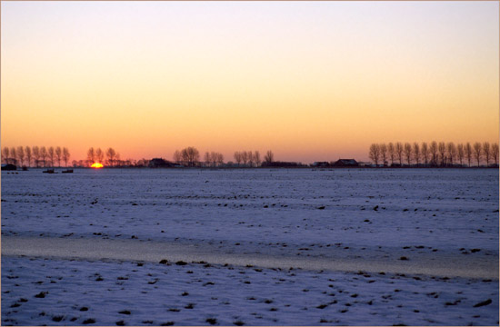 Zonsondergang gezien vanuit de besneeuwde en verijsde Beetskoog