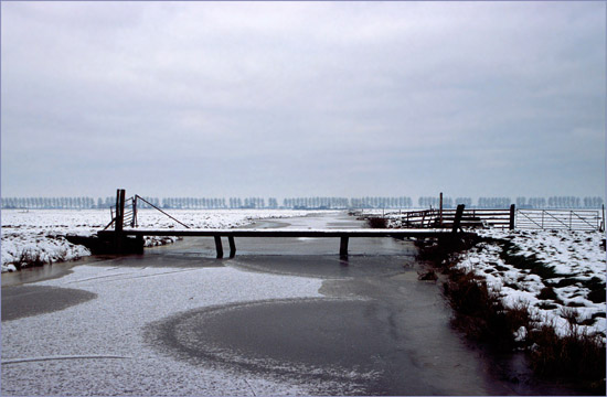 Brug over de bevroren Waterling in de Beetskoog bij invallende dooi