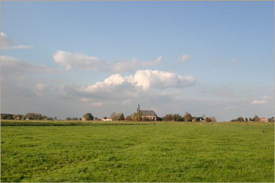 Het kerkje van Oudendijk en wat er omheen ligt in de oktoberzon vanuit de Beetskoog