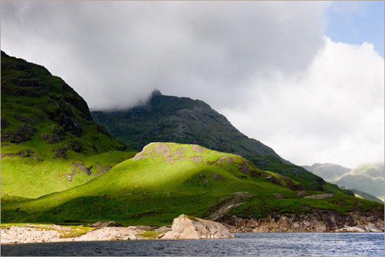 Loch Quoich's West End, with sun bursting around Tom na Cruaiche and Ben Aden in a cloud