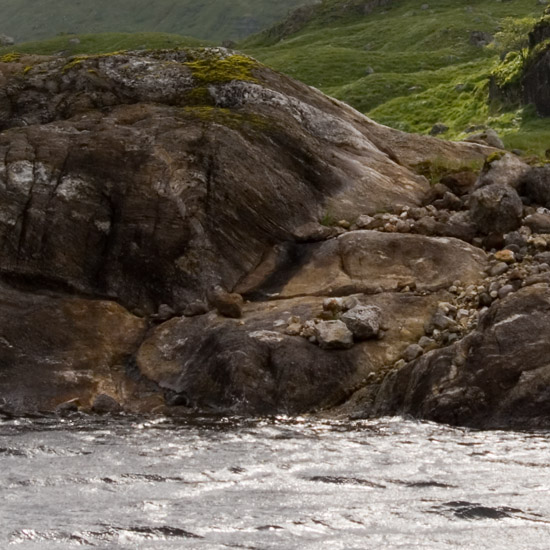 Zoom: The bleak shore of Loch Quoich on a wild day; paltry sunbeams slipping down from over Sgurr Mòr