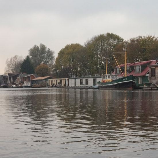 Langs de Where liggen de drijvende huizen met hun boten rustig in de rij